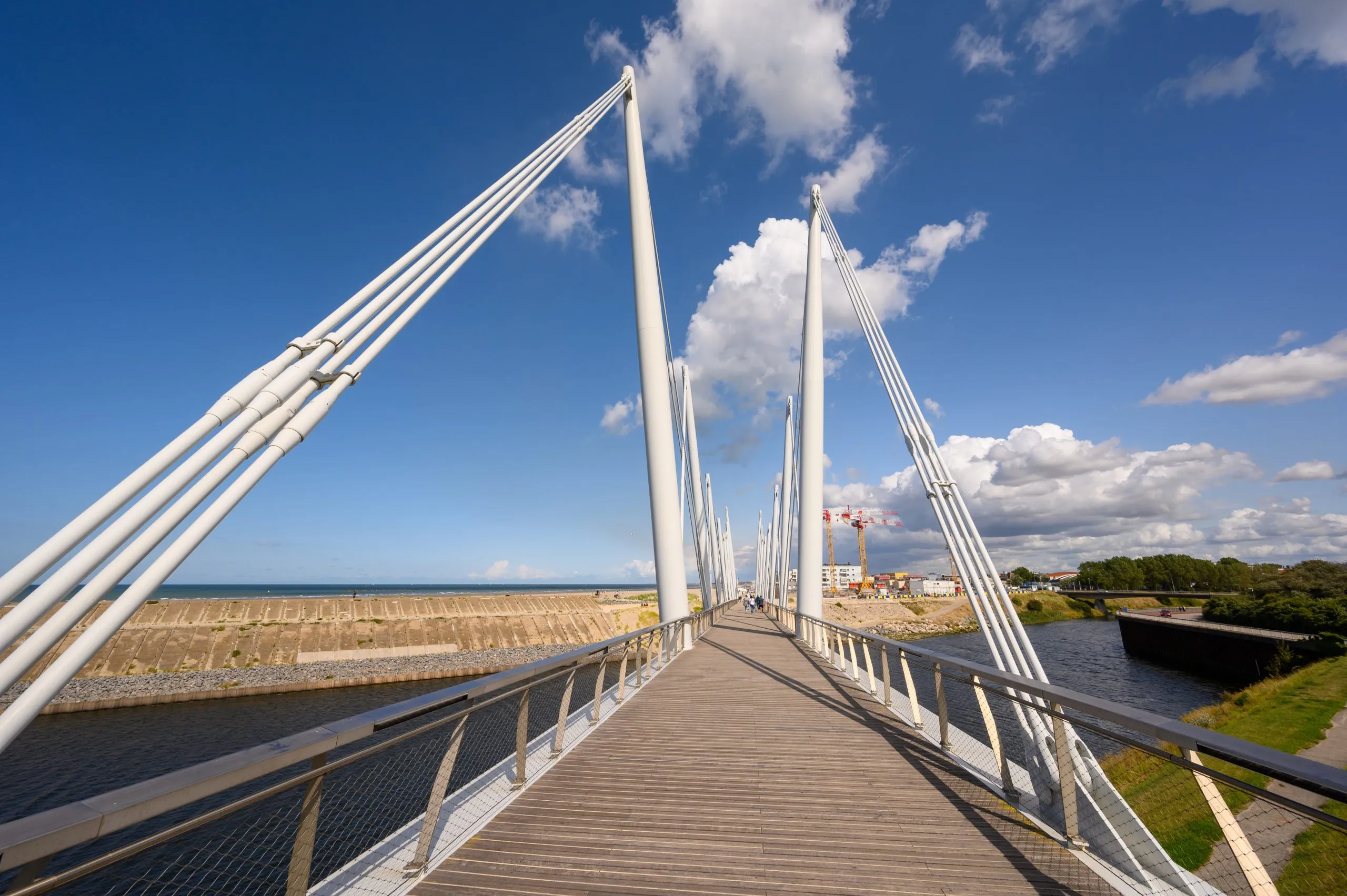 view-along-the-passerelle-du-grand-large-large-bridge-in-dunkirk-france-on-a-sunny-day-with-the-town-in-the-background